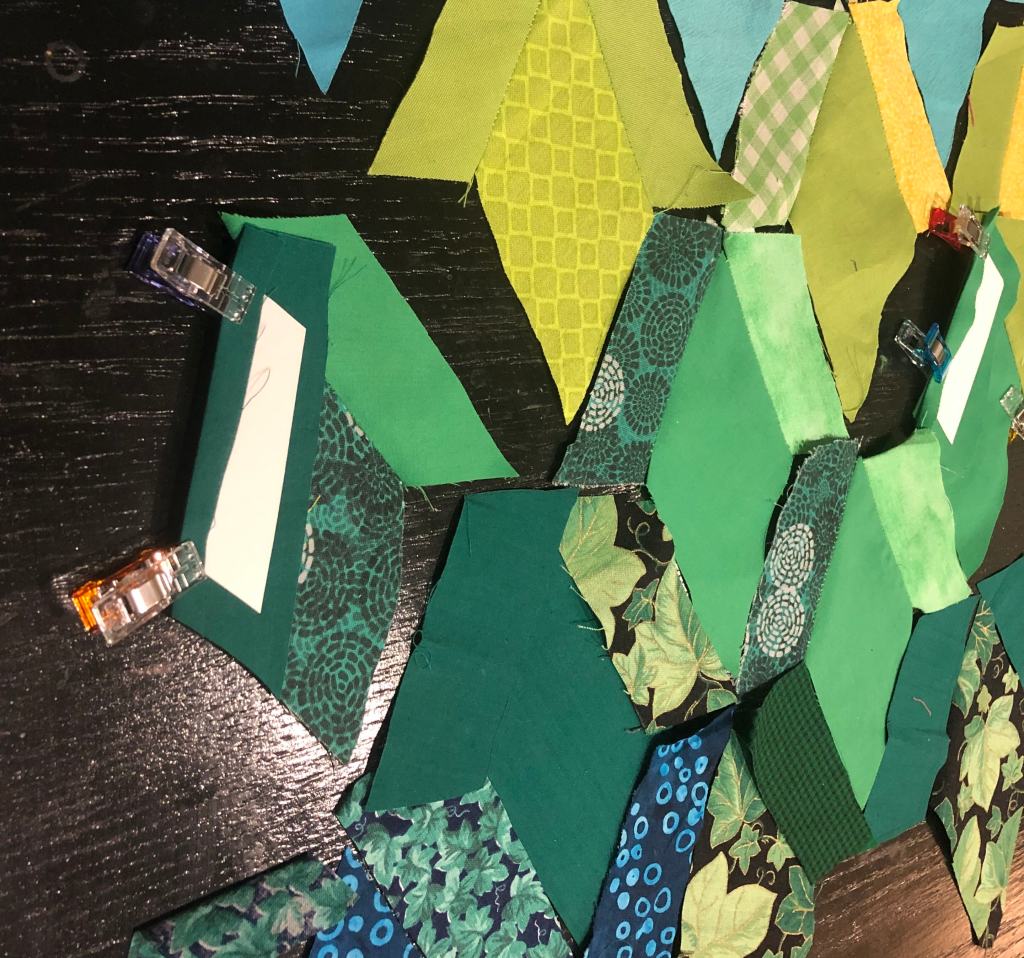 cloth cut to the earlier tesselating pattern demonstrating the clips and paper setup that eases hand stitching 