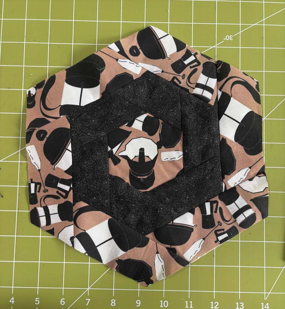 hexagon log cabin quilt block dominated by a pattern of moka pots and french presses