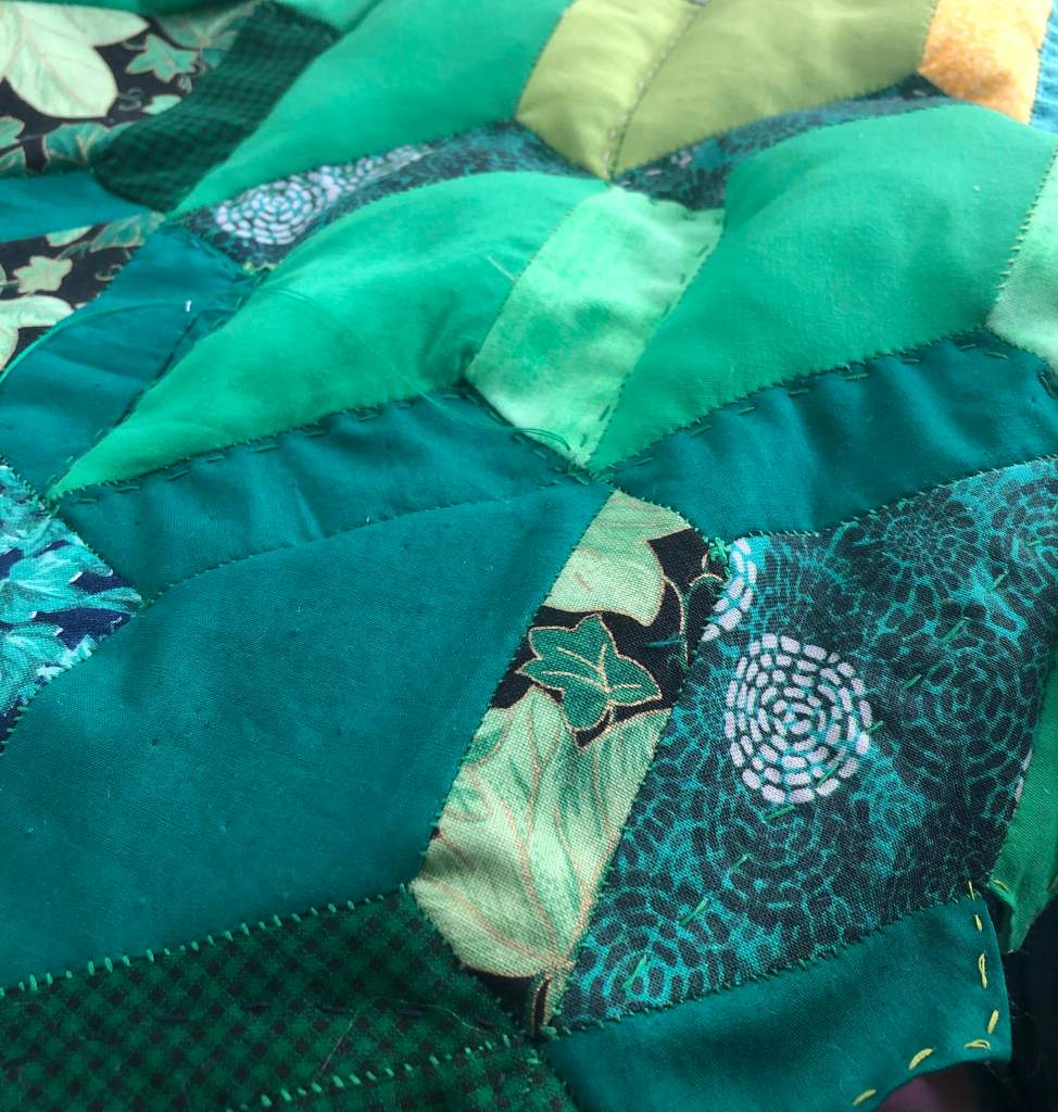 patchwork in the process of being quilted to the interfacing and lining. some bits of patchwork have been overstuffed to emphasize the ivy design